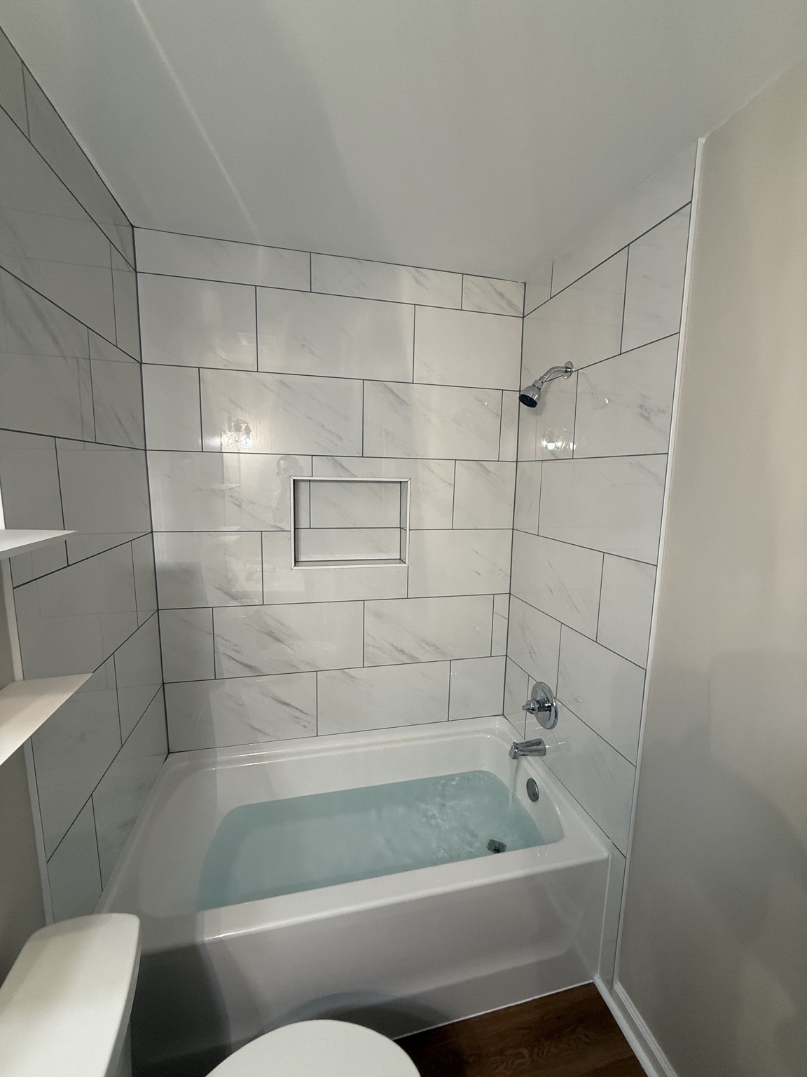 Modern bathtub and white tile shower